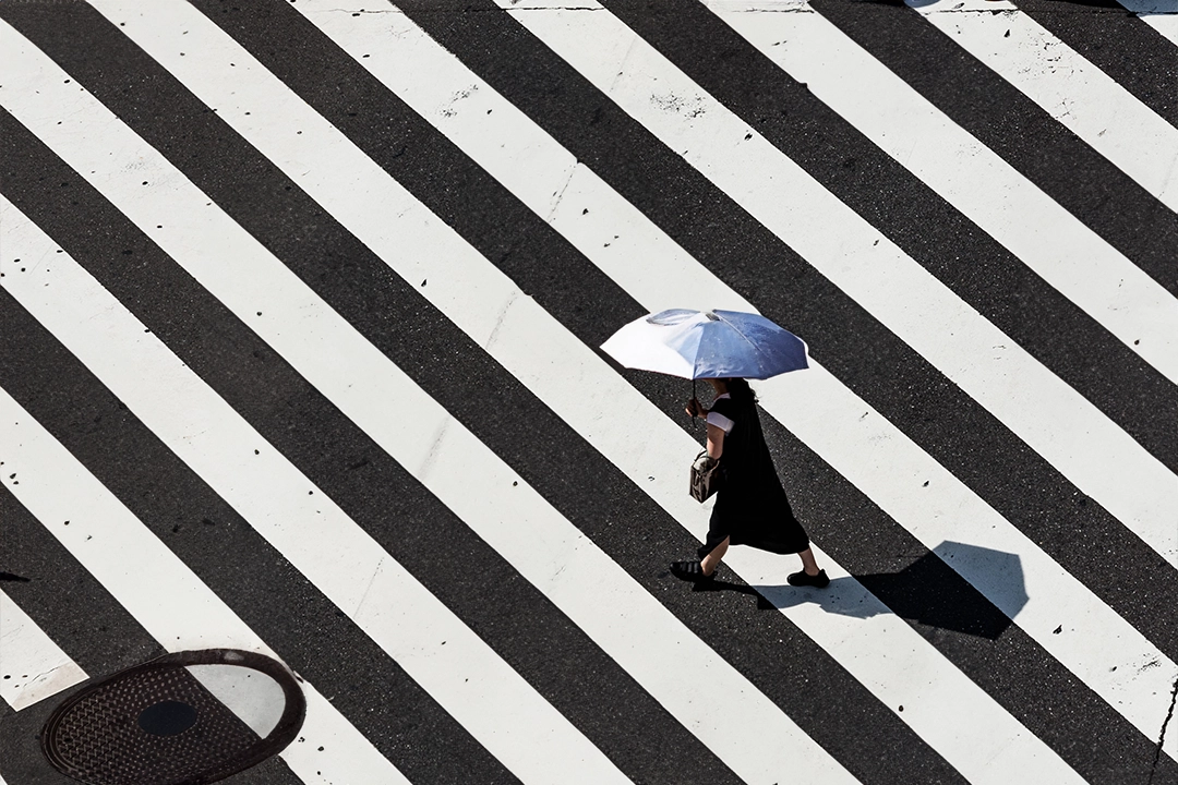 woman crossing the street with an umbrella